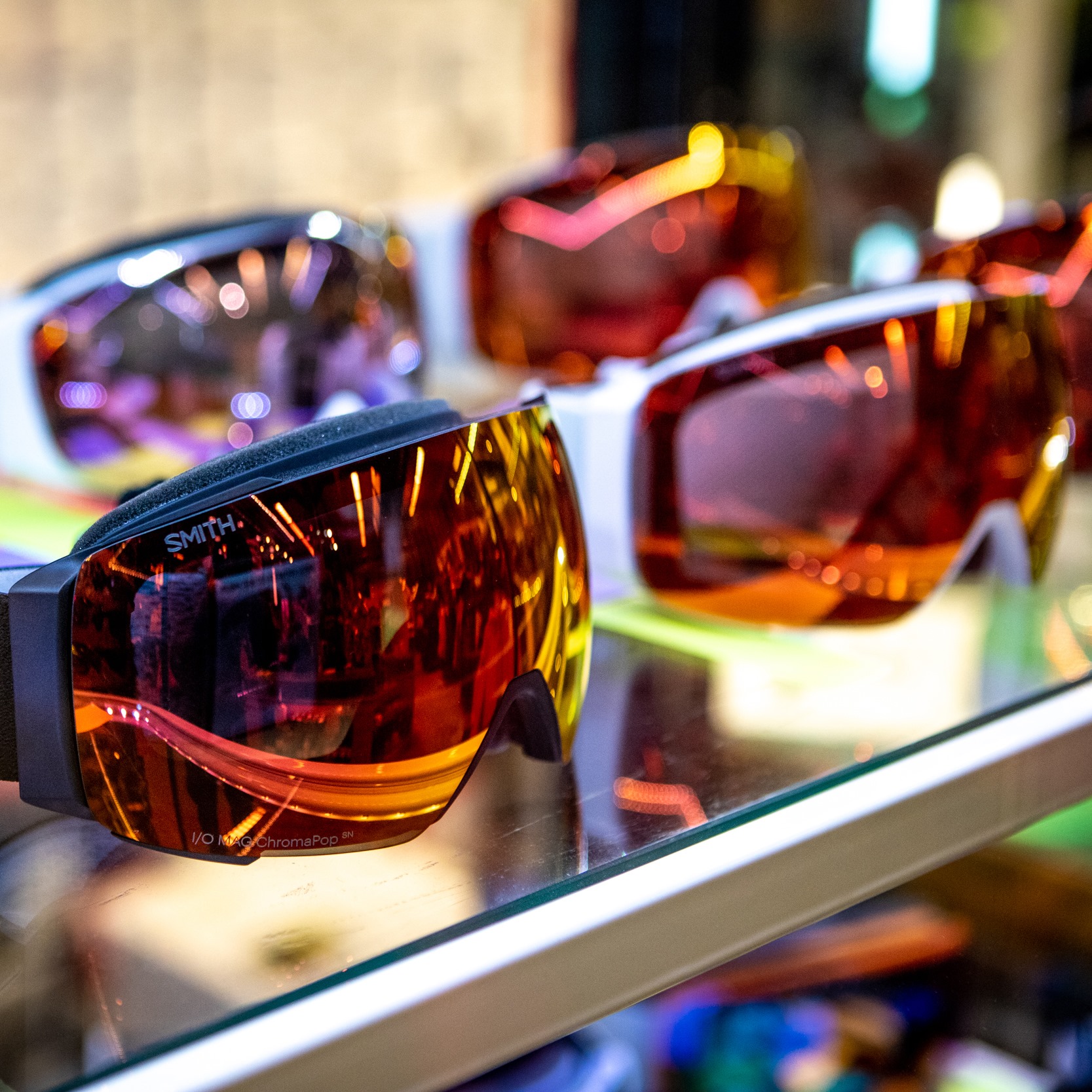 A line of shiny ski goggles with red glass at the MTNSide Shop