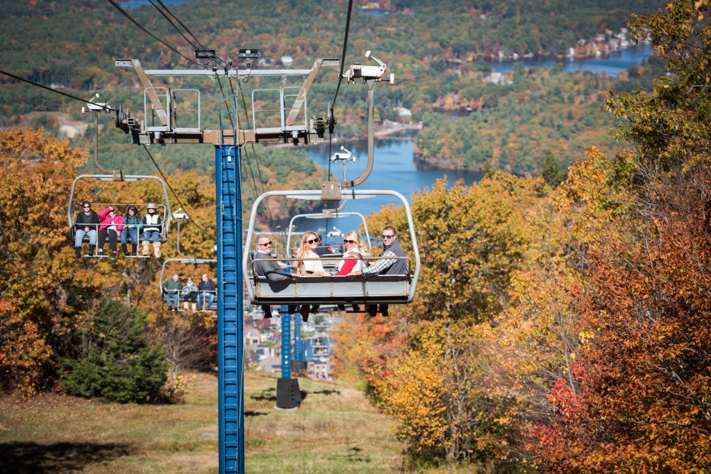 Four people on lift with fall foliage